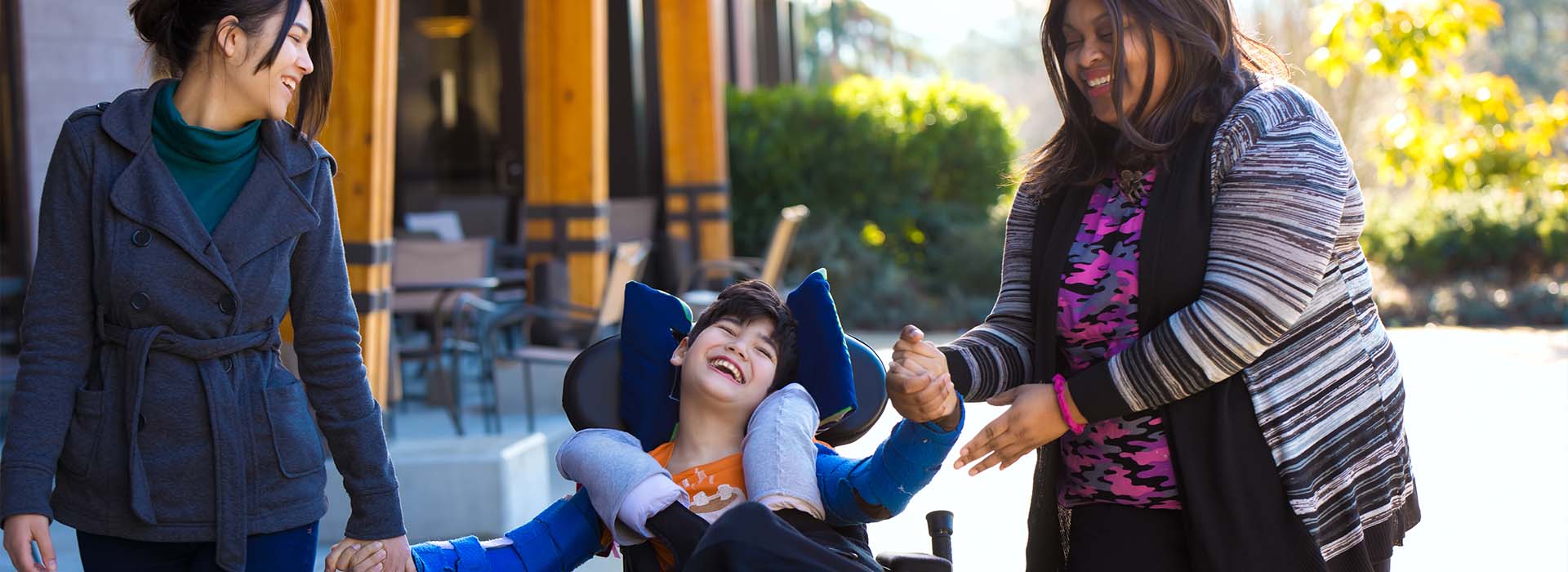 A caregiver from Total Support Home Care LLC helping a child in a wheelchair
